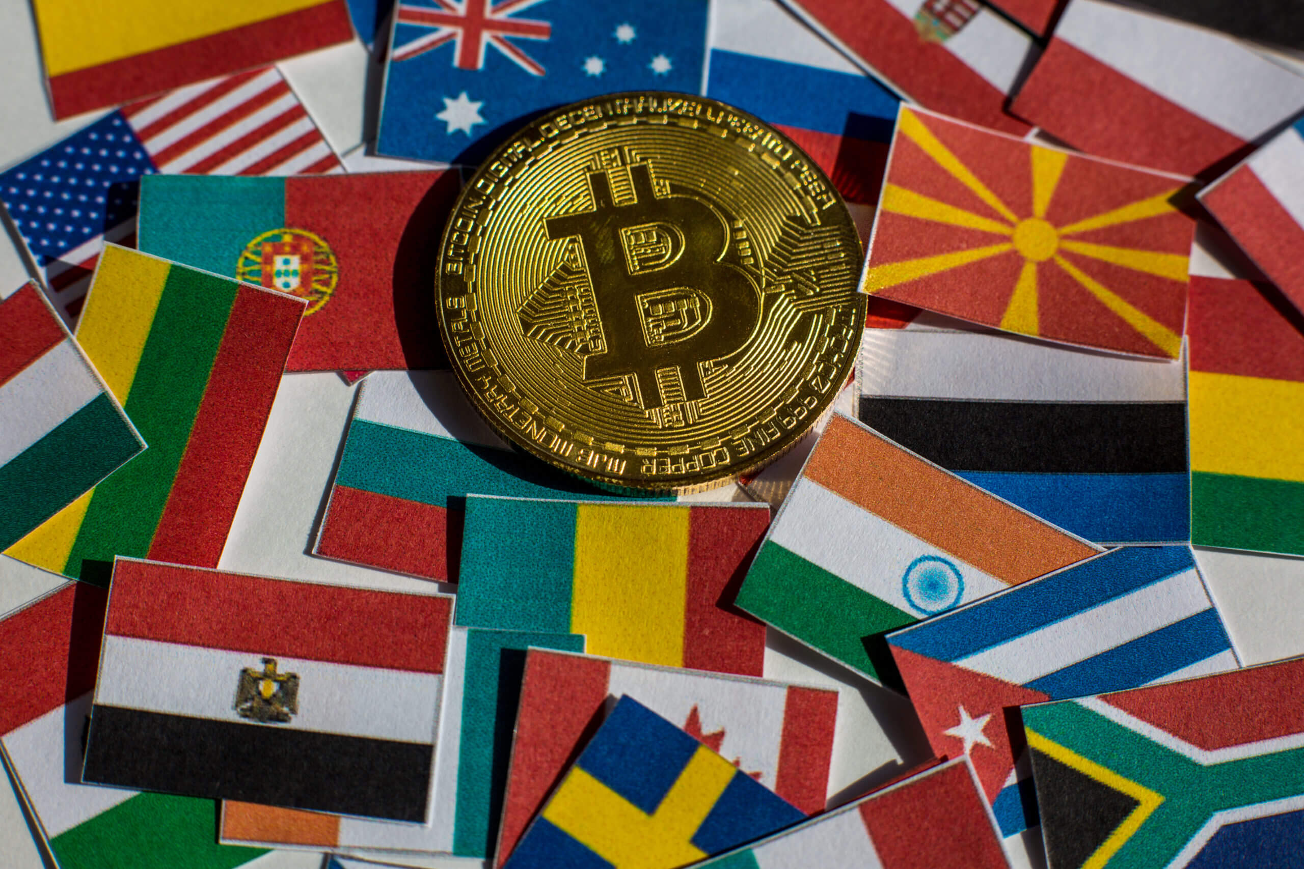 Bitcoin coin surrounded by flags from different countries
