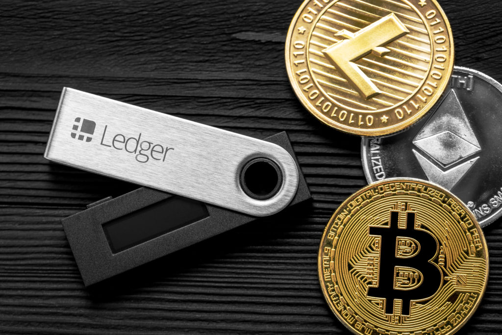 A ledger USB with Bitcoin, Litecoin and Ethereum next to it