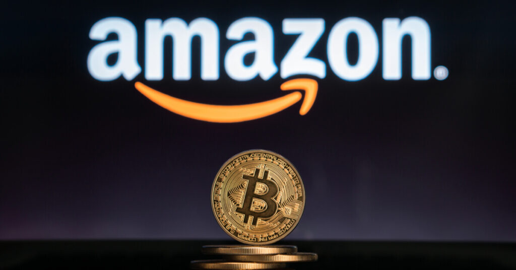 Gold Bitcoin at the foreground of an Amazon logo