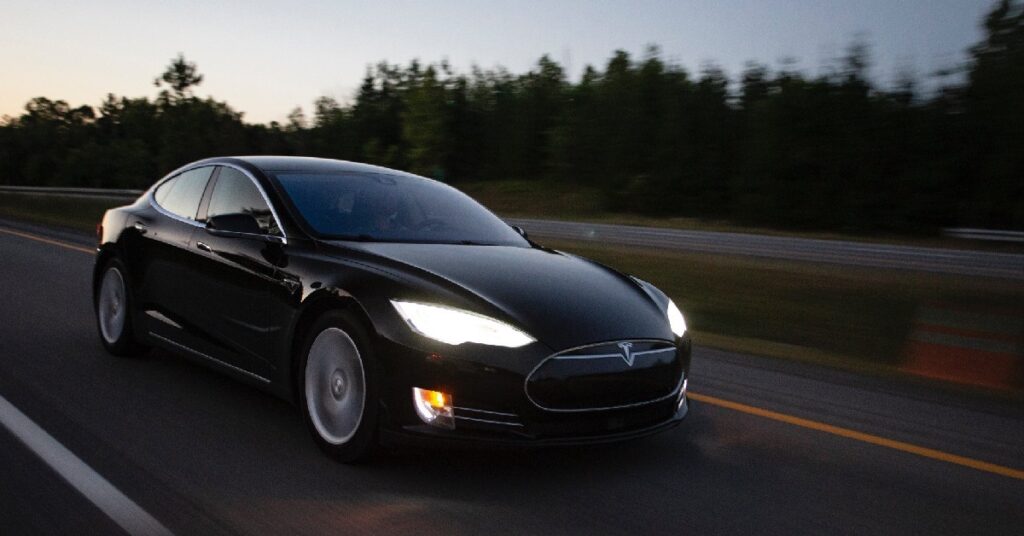 A black Tesla car on the road