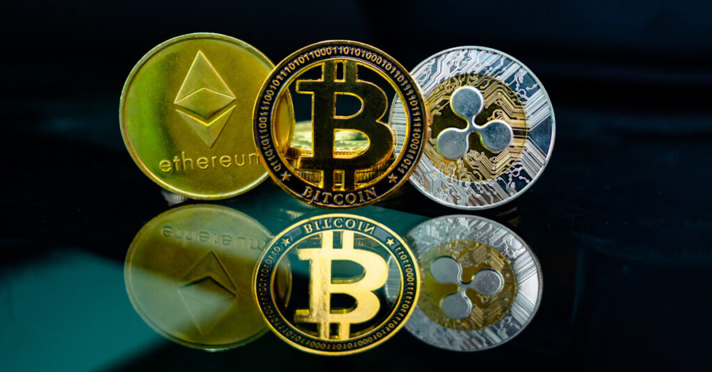 Ethereum, Bitcoin, and Ripple coins with reflection on black background