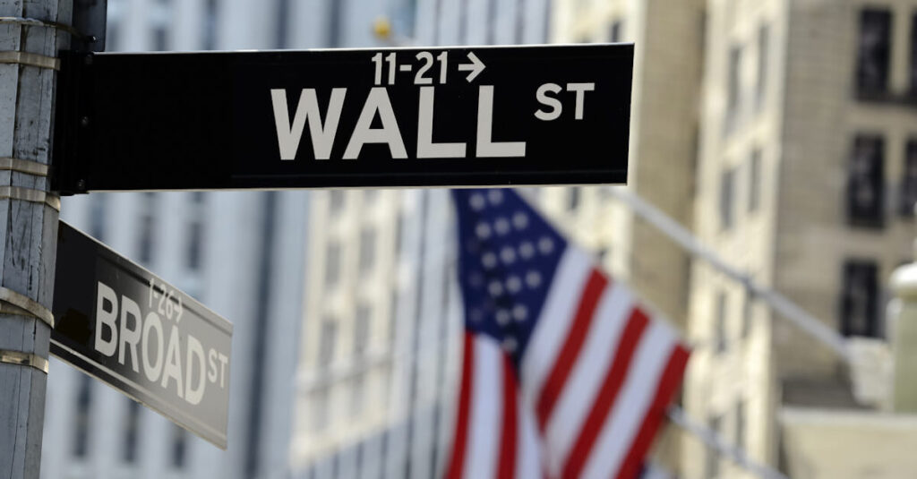 United States flag behind a Wall Street sign