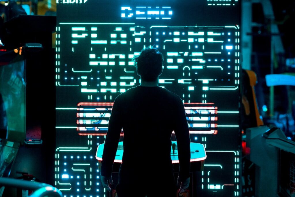 A person standing at a Pac-Man game