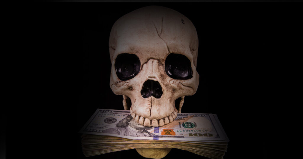 A skull with dollar bills in its mouth