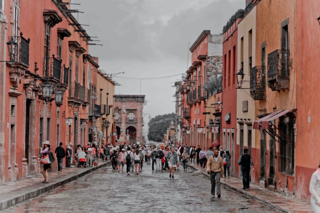 A wide street among buildings under a grey cloudy sky