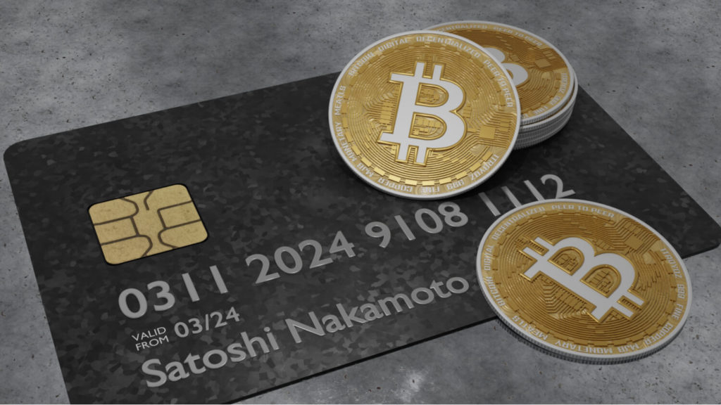 Tarjeta de crédito con el nombre de Satoshi Nakamoto bajo monedas Bitcoin