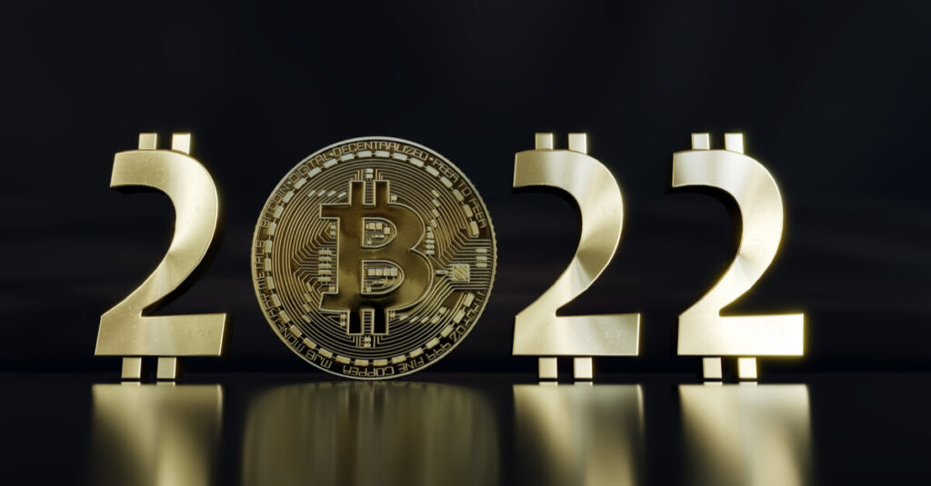 A 3D rendering of the numbers 2022 with the zero replaced by a Bitcoin, represented in physical gold coin form, in front of a dark background.
