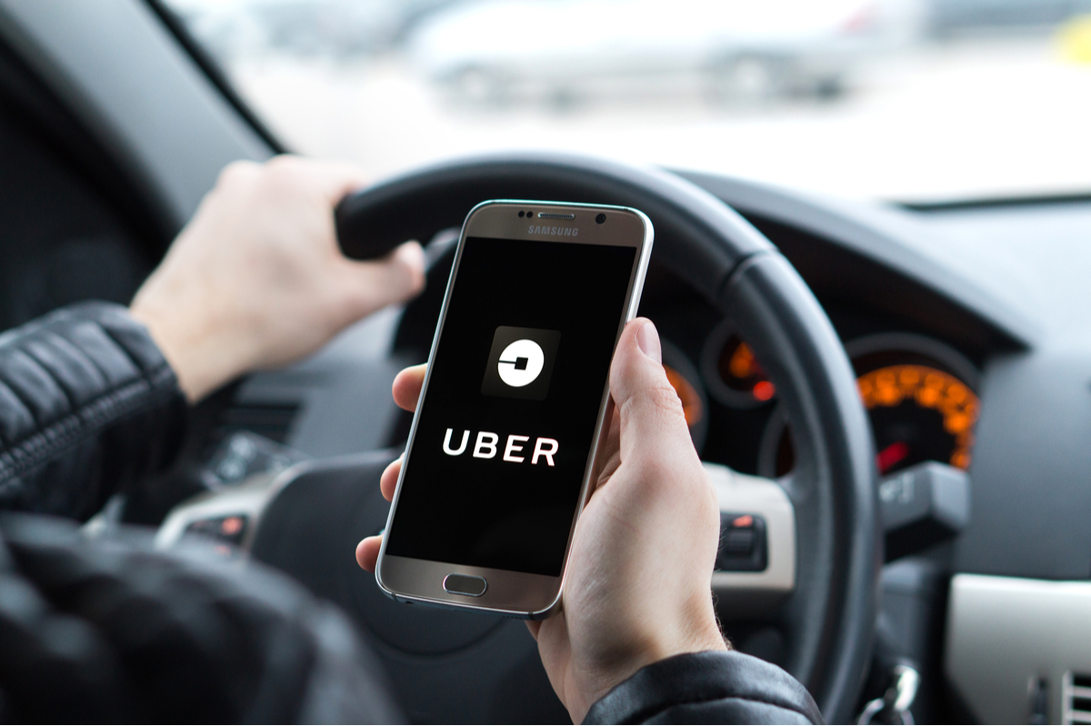 Uber logo on a smartphone screen situated within a car