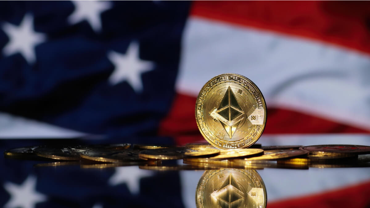 A golden Ethereum coin sitting in front the U.S. flag