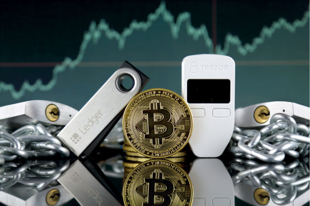 Gold Bitcoin between a Ledger and Trezor Hardware Wallet