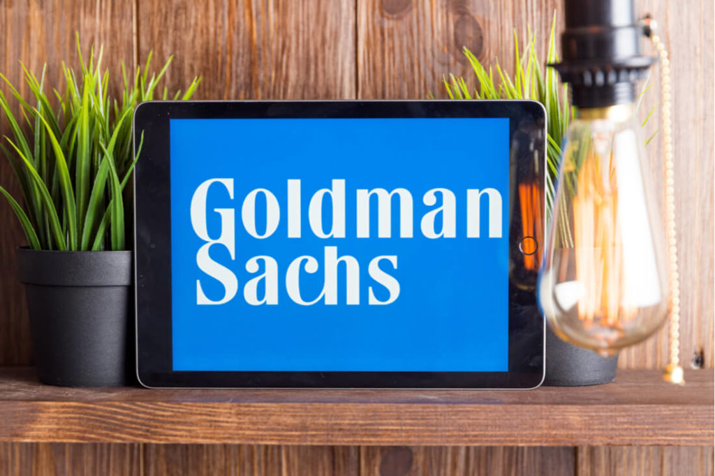 Goldman Sachs logo on an iPad ona  wooden shelf surrounded by plants