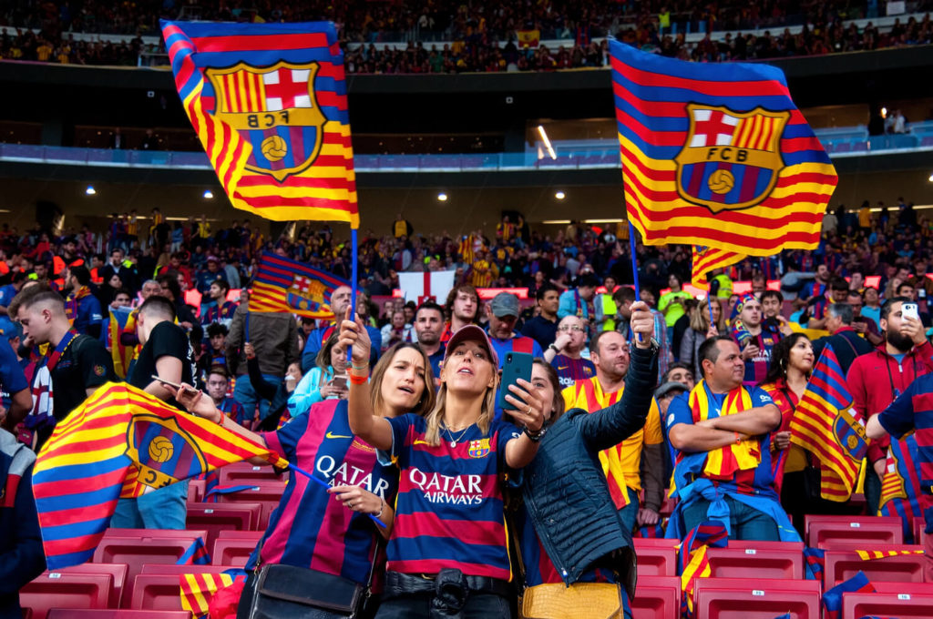 People in the stands at an FC Barcelona game,