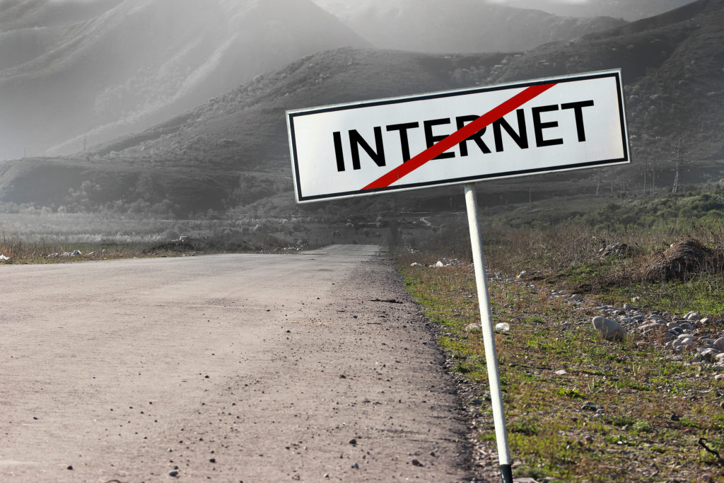 Cartel con la palabra "Internet" tachada en una carretera vacía 