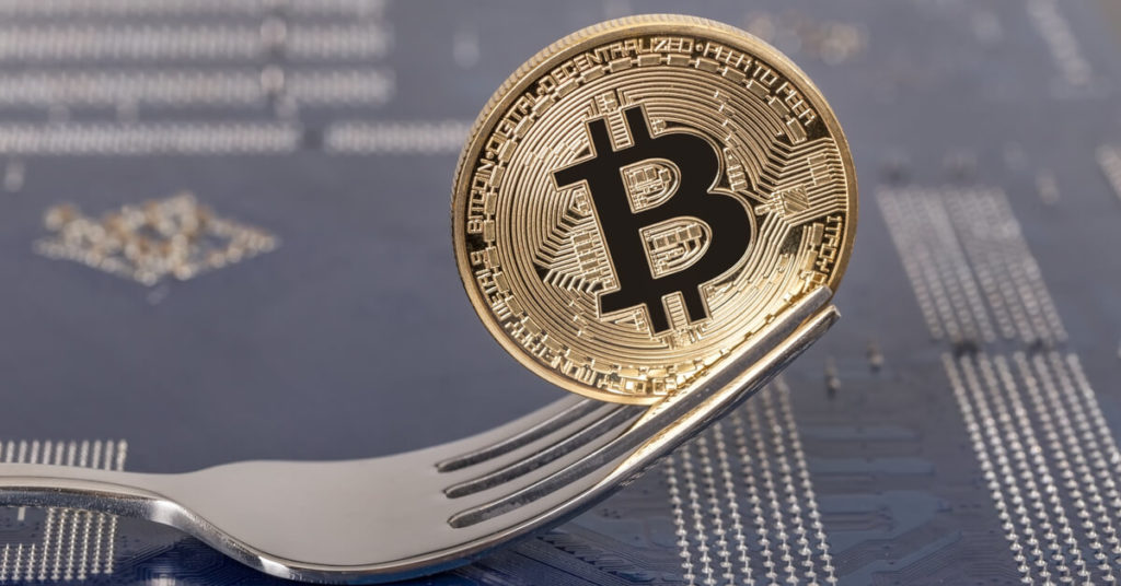 Bitcoin coin attached to a fork representing a bitcoin fork 