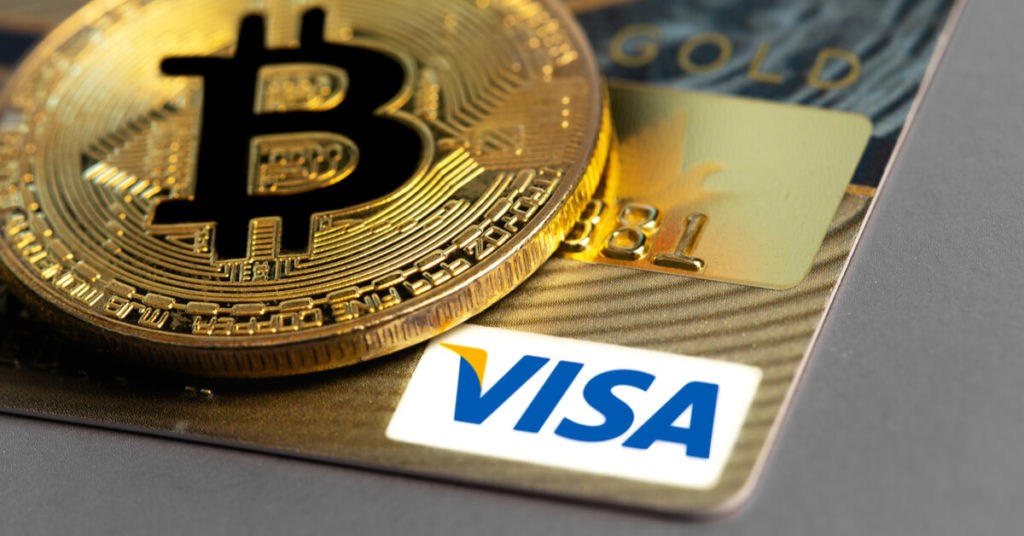 Visa gold with a Bitcoin coin on top of it