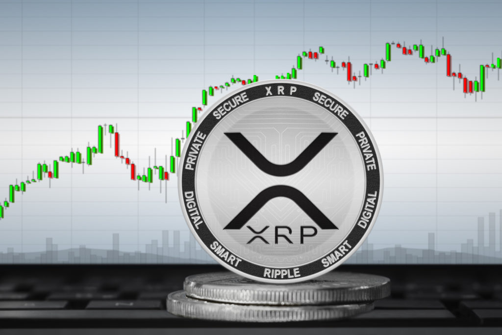 xrp coin sitting atop 2 other coins with a rising graph in the background