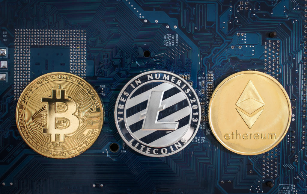 Bitcoin, Litecoin and Ethereum coin set against a blue background representing blockchain