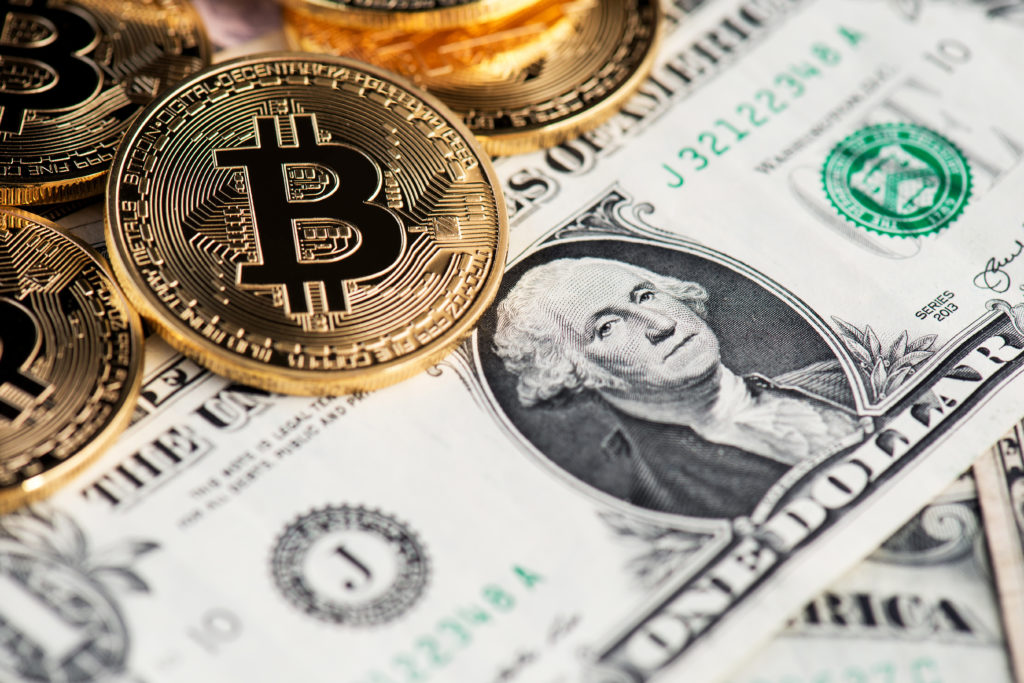 Bitcoins sobre un billete de dólares 