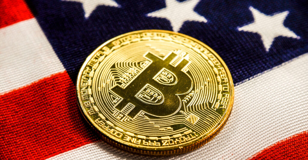 Bitcoin gold coin on top of a US flag