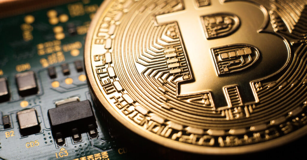 A zoomed image of golden Bitcoin resting on an internal microchip
