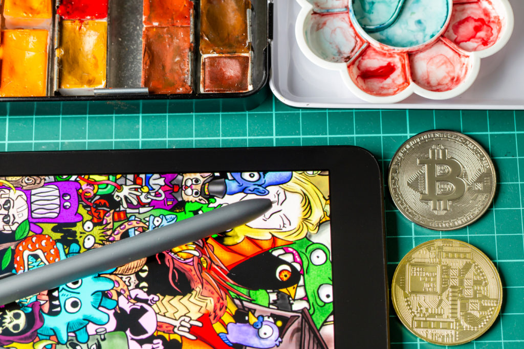 Tablet and stencil lying on a table next to painting equipment and a golden Bitcoin.