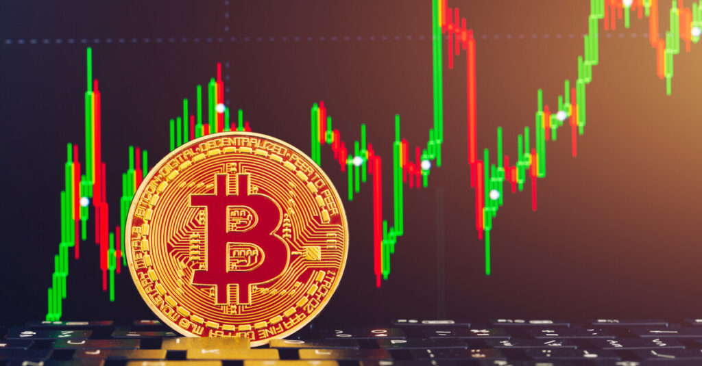 Image of golden Bitcoin turned upside down in front of a rising candlestick chart