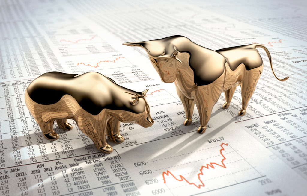 a golden bull and bear laid on a financial graph