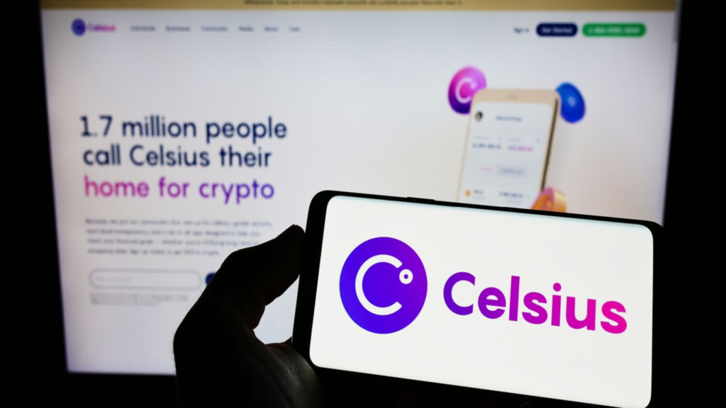 Image of a smartphone showing the Celsius logo, being held in front of a laptop showing the Celsius website