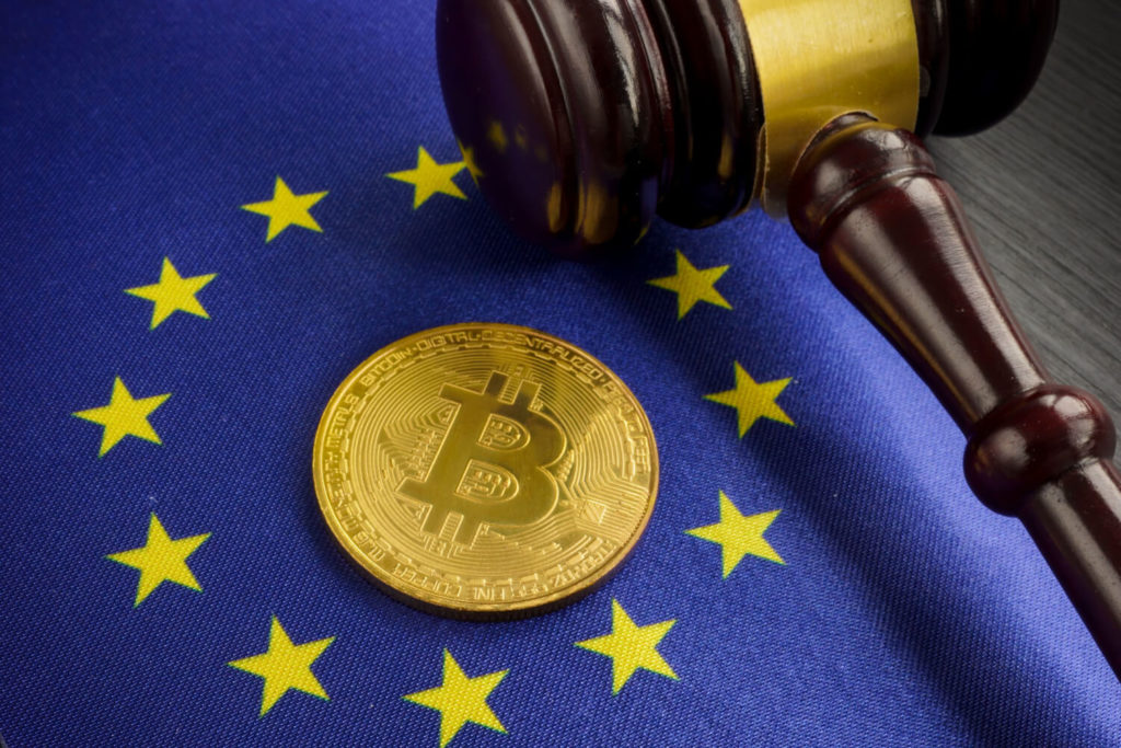 EU stars surrounding Bitcoin on a blue drape with a hammer next to them