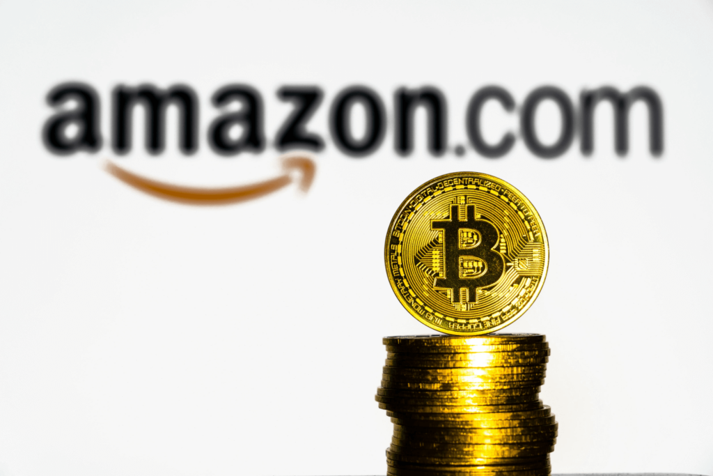 Amazon logo next to two golden Bitcoins