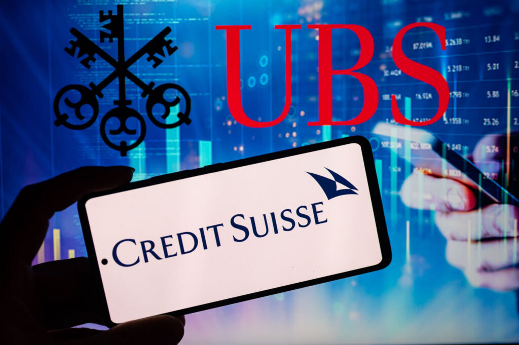 ubs and credit suisse logos on mobile phone screen with stock charts in the background