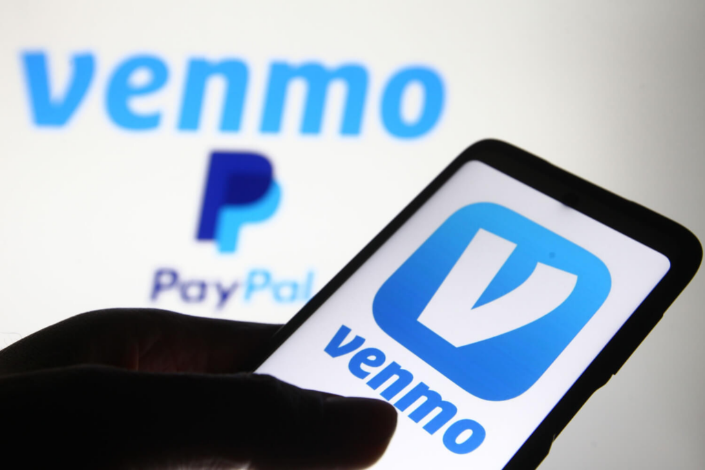 Logo of Venmo on a smartphone in front of a logo of PayPal
