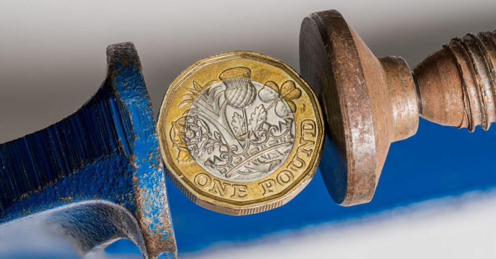 Pound coin held in clamp