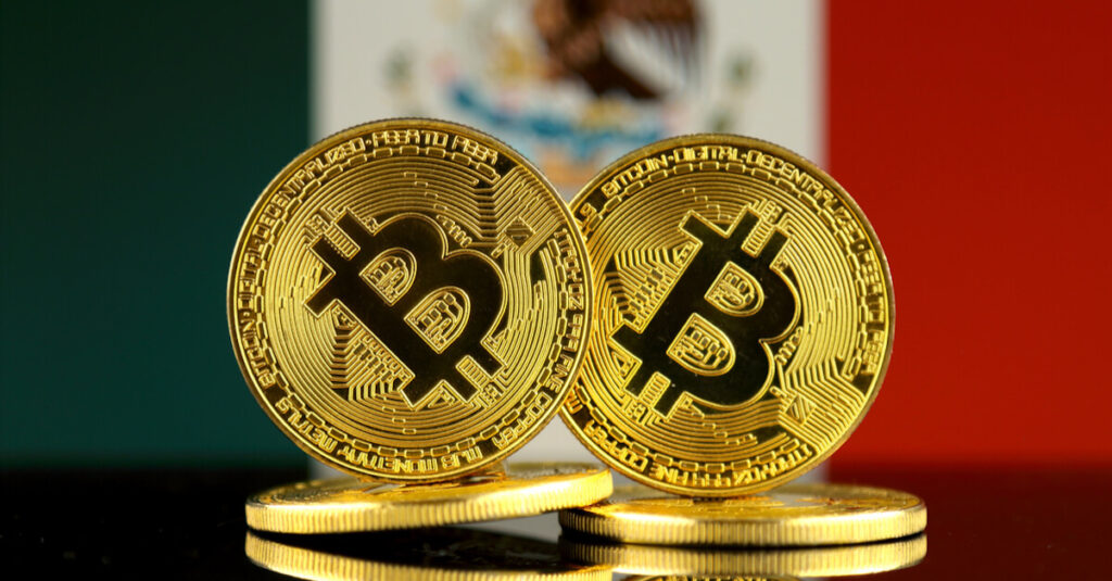 Bandera de México detrás de dos monedas bitcoin