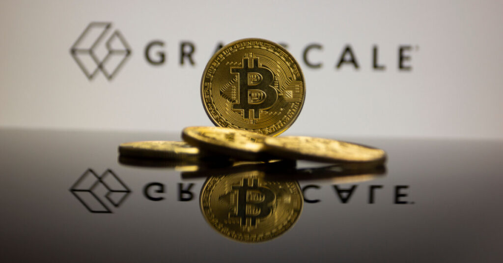 gold bitcoin in front of grayscale logo