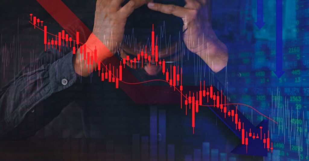 man holding head behind falling bitcoin price chart